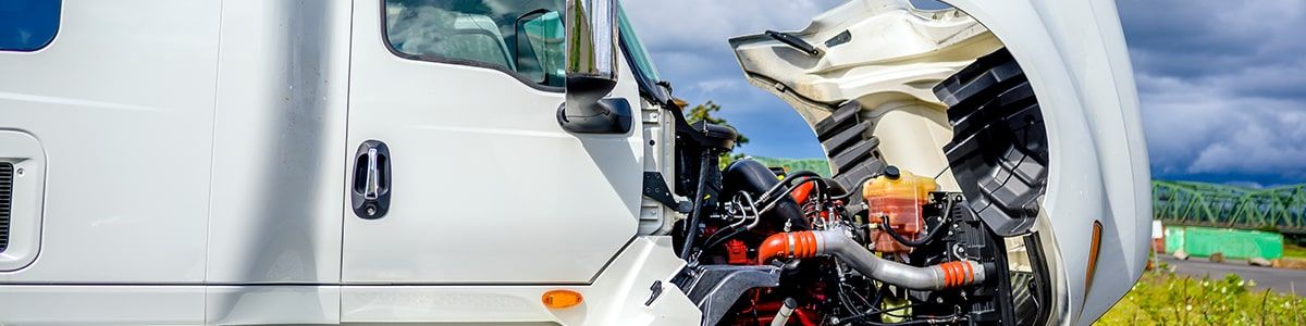 A parked semi-truck with the hood open