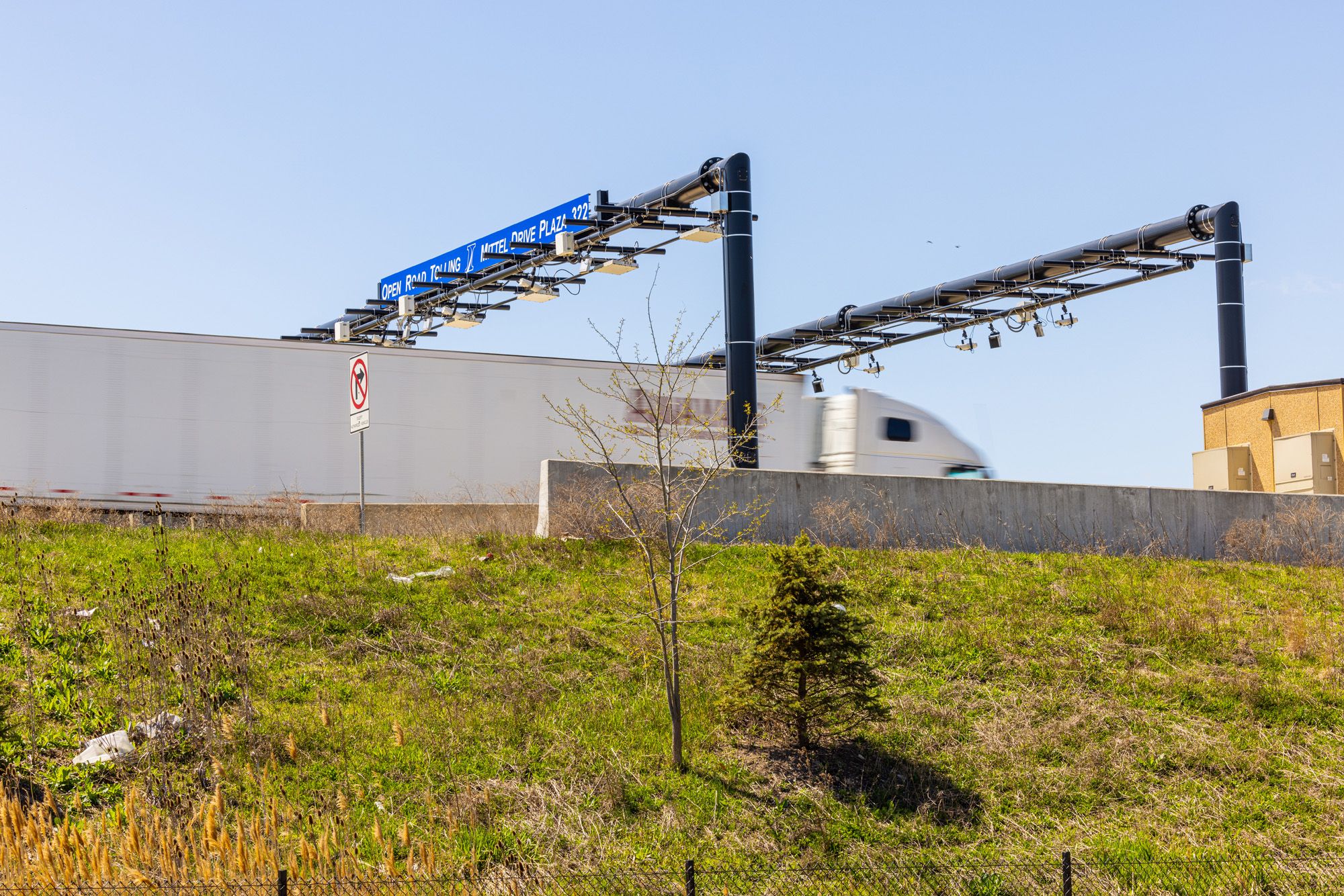 white tractor trailer driving through toll plaza