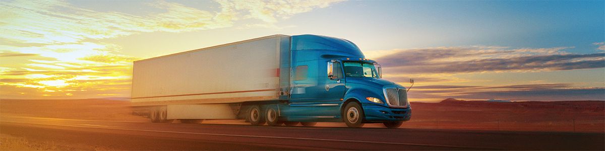 An electric blue truck is speeding down an orange desert road, slightly blurry